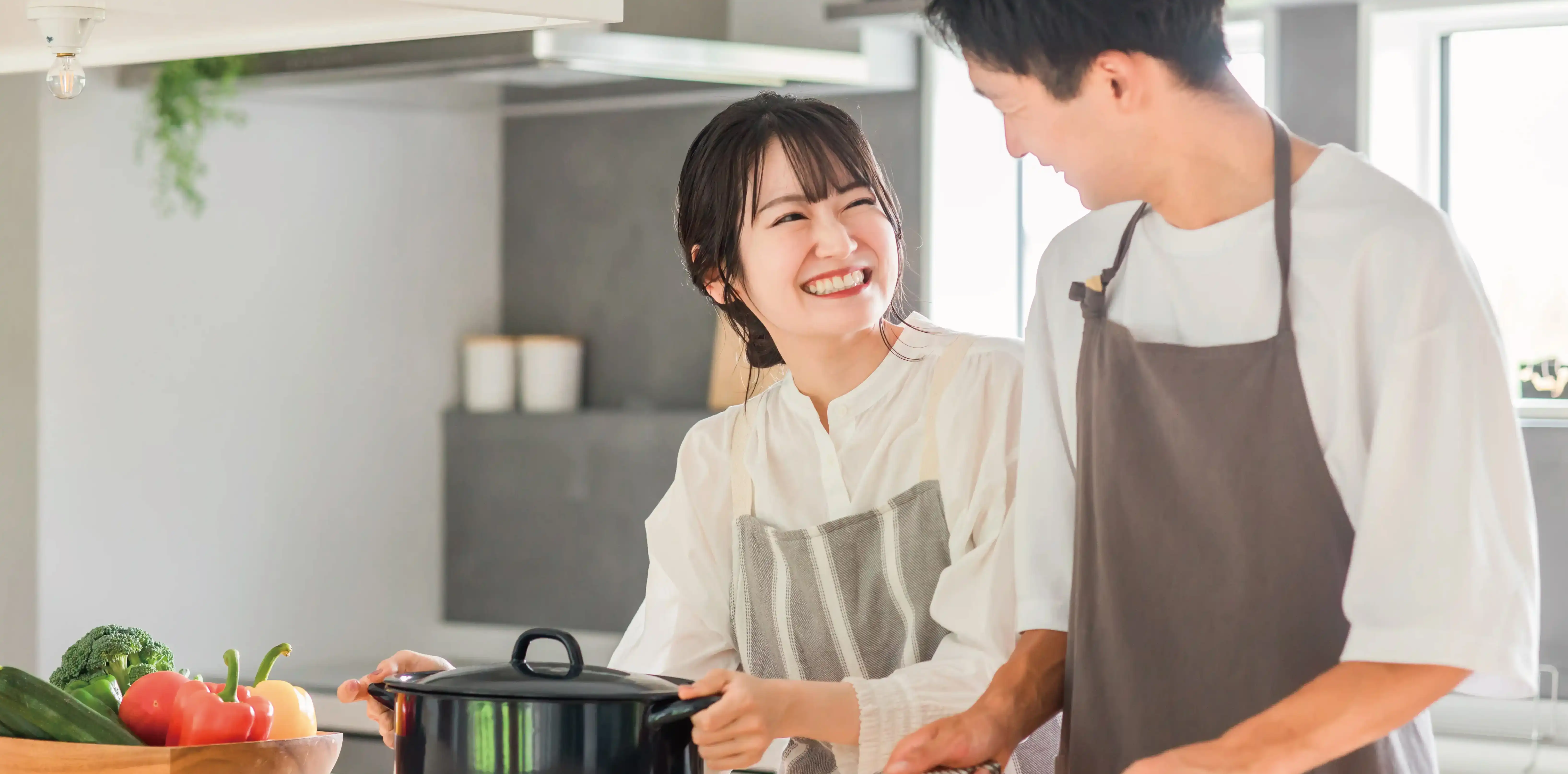 明るいキッチンで夫婦が料理を楽しむSAN+平屋の暮らしイメージ